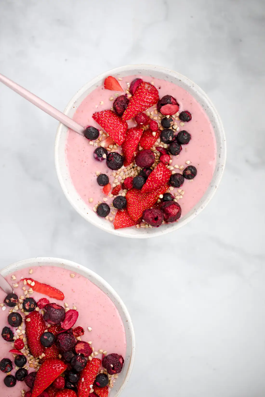 Ružová smoothie bowl s jahodami, čučoriedkami a semienkami, pohľad zhora